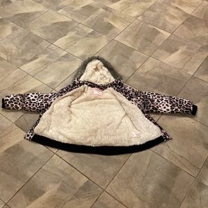 A winter jacket Cheetah print with black brown gray and pink on it